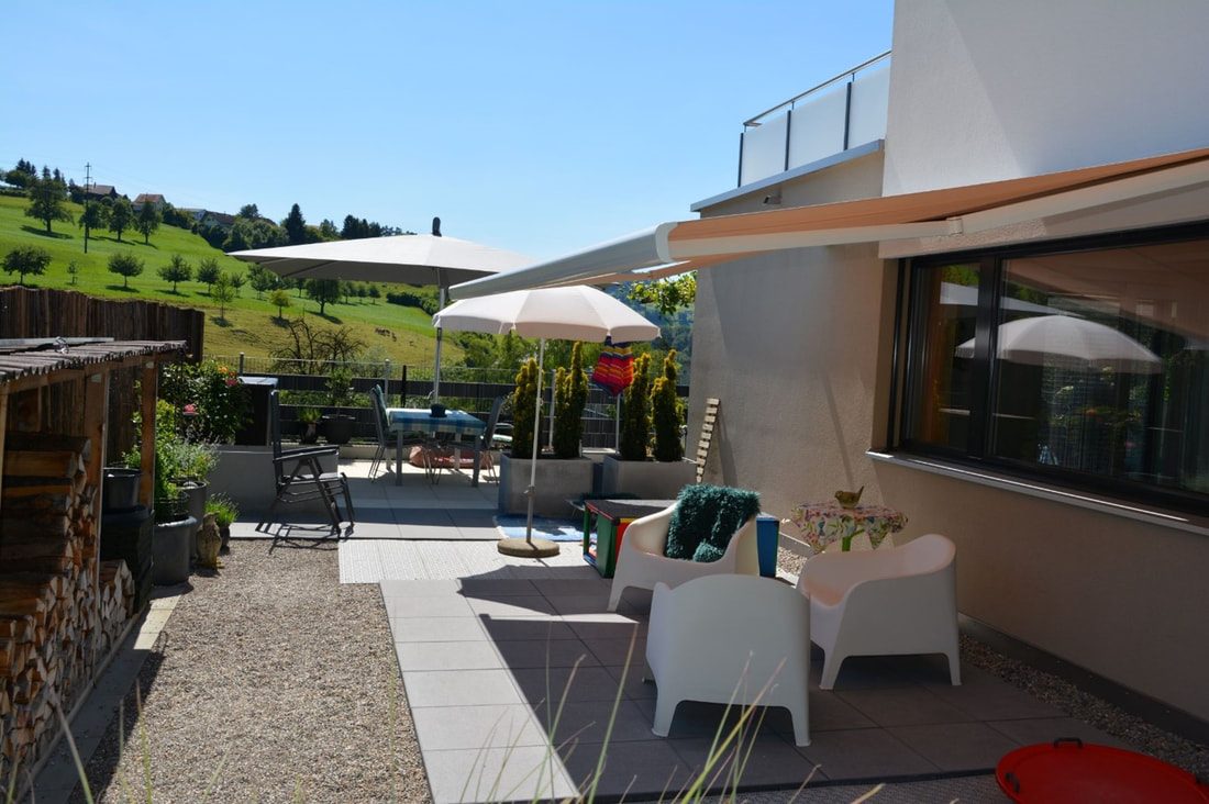 Garten mit Rasen und Sitzplatz vor dem Haus